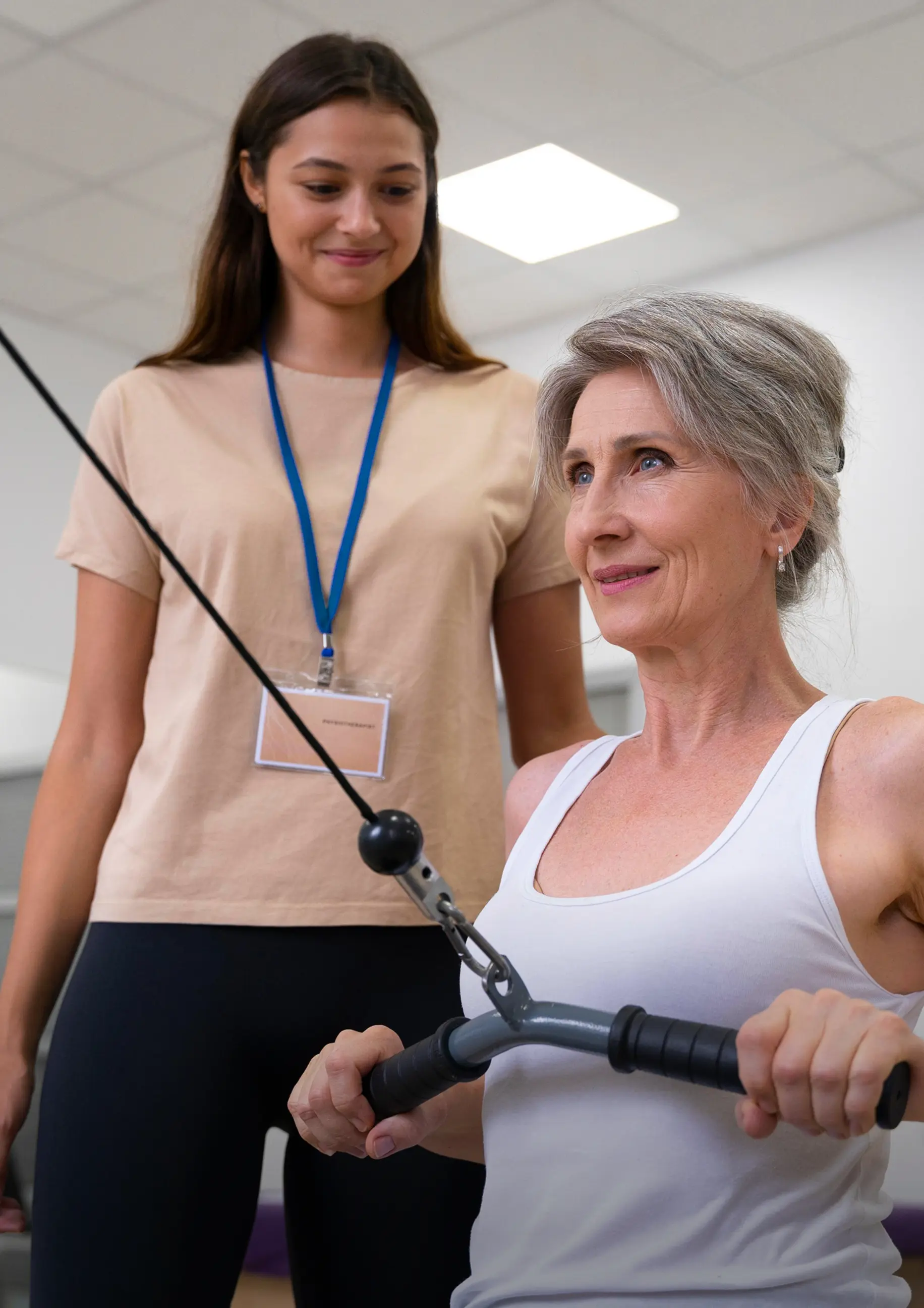 Exercise physiologist guiding a patient through a cable exercise